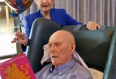 Blue reading his 99th birthday card from his sister Betty